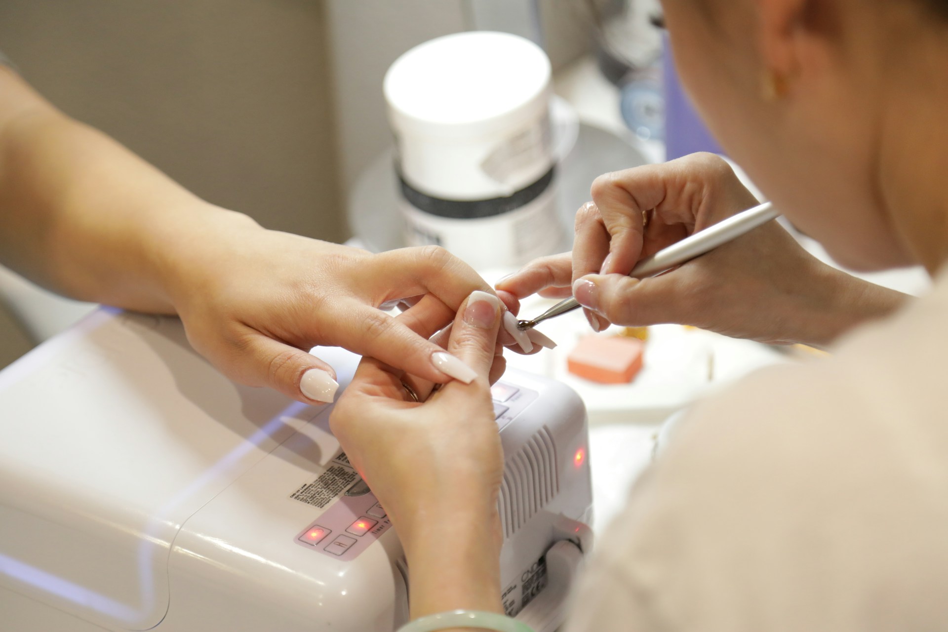 Une professionnelle procède à une manucure.