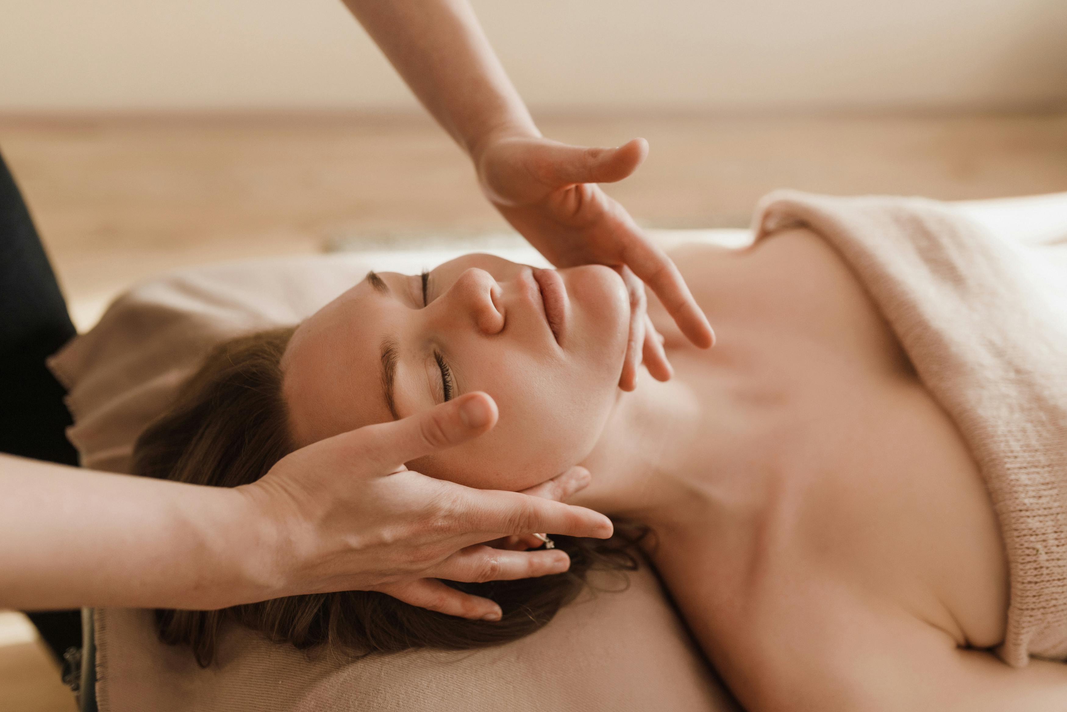Une masseuse en train de réaliser un soin bien-être sur une patiente dans un spa;